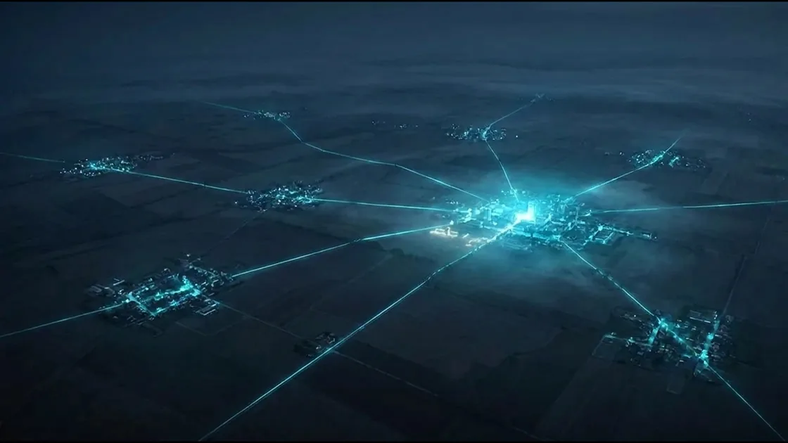 Aerial view at night of small towns linked by glowing fiber lines into a regional hub